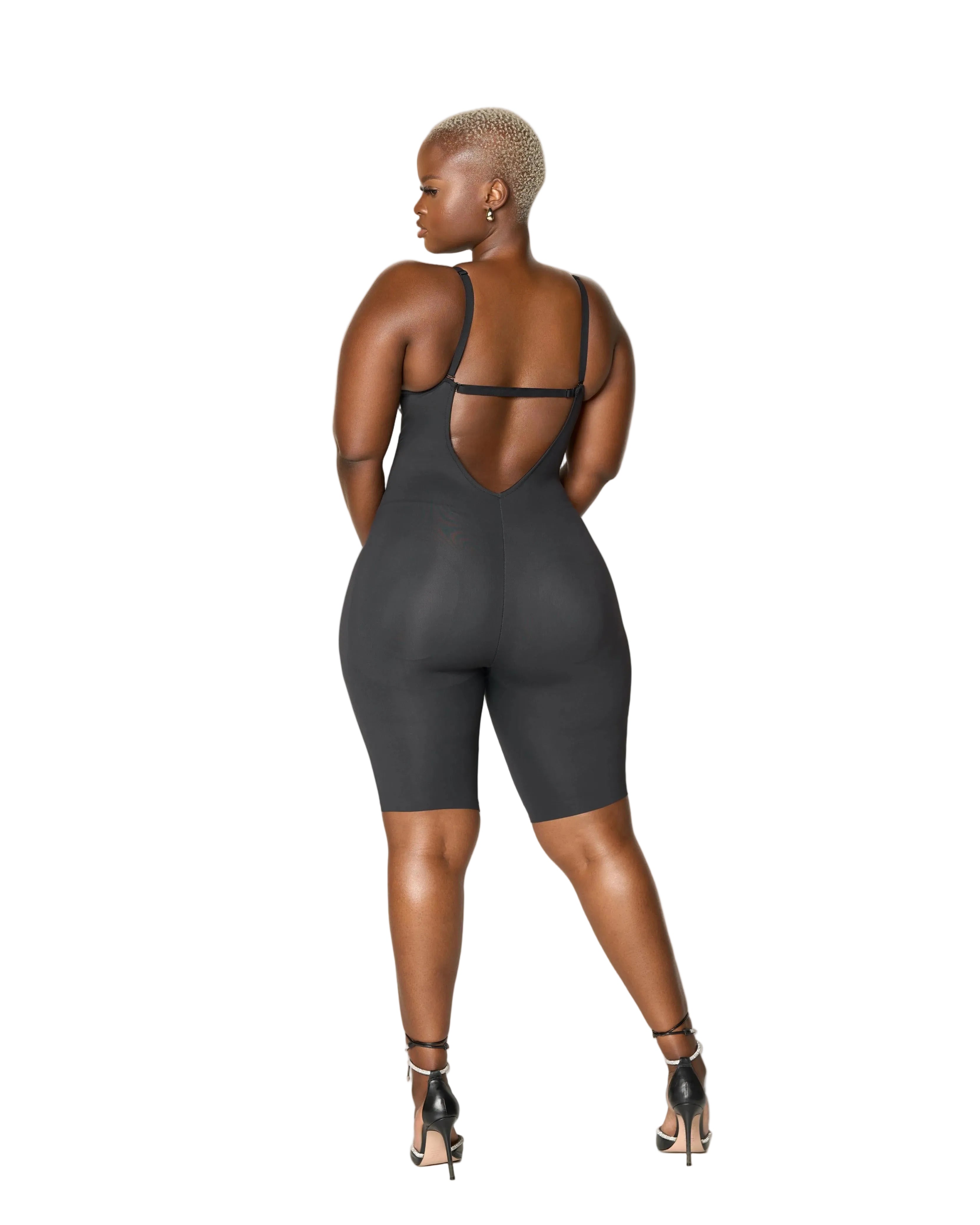 Woman wearing a black bodysuit against a white background