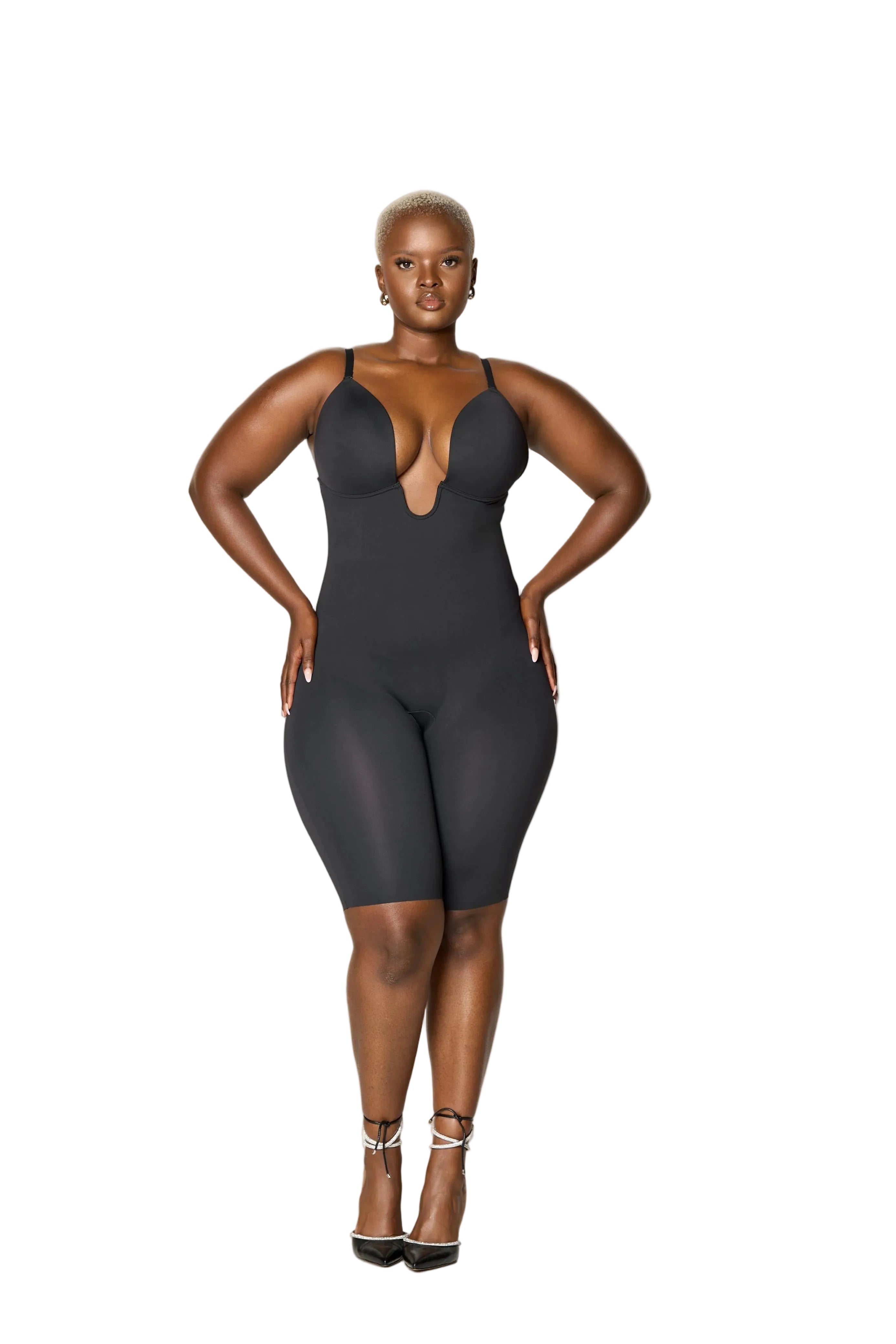 Woman wearing a black bodysuit against a white background